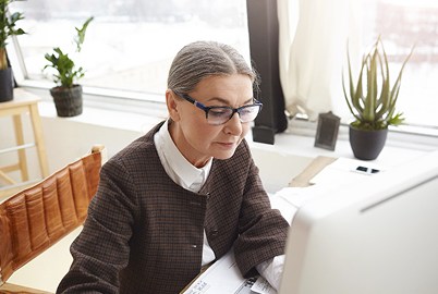 A woman reviewing her work at a desk