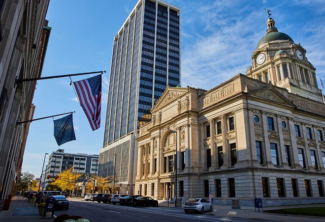 A city hall with flags flying in front of it